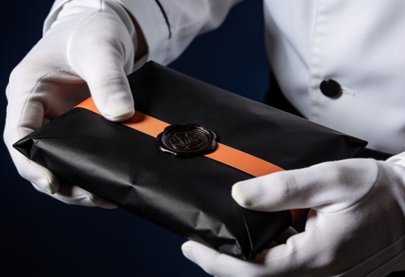 Diskrete White-Glove-Übergabe eines versiegelten Wertpakets